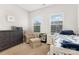Bright bedroom featuring two windows, a cozy chair, and a stylish blue and white bed at 3332 Katherine Taylor Ct, Monroe, NC 28110