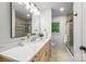 Bright bathroom featuring a quartz countertop vanity, modern lighting, and a separate shower area at 3519 Campbell Dr, Charlotte, NC 28205