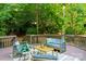 Outdoor deck area featuring comfortable seating, a stylish rug, and wooded surroundings at 3519 Campbell Dr, Charlotte, NC 28205