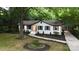 Quaint home with manicured landscaping, including dark mulch beds, surrounded by mature trees and shrubbery at 3519 Campbell Dr, Charlotte, NC 28205
