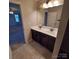 Bathroom featuring a dual sink vanity with decorative lights, a mirror, and tan colored tile flooring at 3717 English Garden Dr, Gastonia, NC 28056
