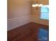 A formal dining room featuring hardwood floors, white trim, and natural light from a large window at 3717 English Garden Dr, Gastonia, NC 28056