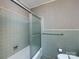 Bathroom features a shower and tub with green tiled walls and floors at 3881 Wood Duck Ln, Denver, NC 28037