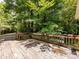 Wooden deck with railing and built-in bench surrounded by trees at 3881 Wood Duck Ln, Denver, NC 28037