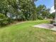 Expansive backyard with lush greenery, mature trees, and a concrete patio perfect for outdoor activities at 4014 Stockbrook Dr, Charlotte, NC 28215