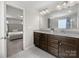 Bathroom vanity area featuring double sinks, granite countertops, and attractive dark wood cabinets at 4014 Stockbrook Dr, Charlotte, NC 28215
