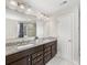 Bathroom vanity area featuring double sinks, granite countertops, and attractive dark wood cabinets at 4014 Stockbrook Dr, Charlotte, NC 28215