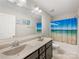 Bright bathroom with double sinks, vanity and beach themed shower curtain at 4014 Stockbrook Dr, Charlotte, NC 28215