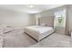 Well-lit bedroom with large bed, a sitting chair, and ample natural light from the windows at 4014 Stockbrook Dr, Charlotte, NC 28215