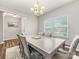 Formal dining room featuring large window, chandelier, and a contemporary table set at 4014 Stockbrook Dr, Charlotte, NC 28215