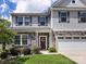 Inviting two-story home featuring a stone facade, a two-car garage, and a cozy front porch at 4014 Stockbrook Dr, Charlotte, NC 28215
