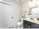 Clean bathroom featuring a toilet, a sink with a dark cabinet, and a door at 4227 Mackinnon Dr, Charlotte, NC 28214