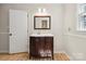 Full bathroom with hardwood floors, wooden vanity, and a large mirror at 4911 Rivergreen Ln, Charlotte, NC 28227