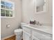 A bathroom with hardwood floors, a toilet, and a white sink with a mirror at 4911 Rivergreen Ln, Charlotte, NC 28227