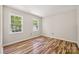 A bright room with light-colored walls, hardwood floors, and two windows letting in natural light at 4911 Rivergreen Ln, Charlotte, NC 28227