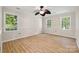 Large bedroom with hardwood floors, fan, and three large windows at 4911 Rivergreen Ln, Charlotte, NC 28227