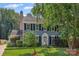 Charming two-story home with blue siding, black shutters, brick chimney, and well-manicured lawn at 4911 Rivergreen Ln, Charlotte, NC 28227