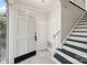 Bright foyer with white walls, staircase, tile floor, and front door at 4911 Rivergreen Ln, Charlotte, NC 28227