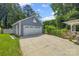 Detached two-car garage with white door, basketball hoop, and landscaped surroundings at 4911 Rivergreen Ln, Charlotte, NC 28227