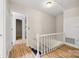 Upstairs hallway featuring hardwood floors and white wainscotting at 4911 Rivergreen Ln, Charlotte, NC 28227