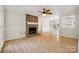 Spacious living room features a brick fireplace, wood floors, and a ceiling fan at 4911 Rivergreen Ln, Charlotte, NC 28227