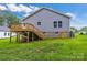 Home exterior with a wooden deck, stairs, gray siding, and a brick foundation at 5185 Grand Canyon Rd, Concord, NC 28027