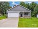 Charming single-story home featuring a covered porch, gray siding, and a two-car garage at 5185 Grand Canyon Rd, Concord, NC 28027