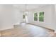 Bright living room featuring hardwood floors, large windows, and modern light fixtures at 5185 Grand Canyon Rd, Concord, NC 28027