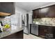 Modern kitchen featuring stainless steel appliances, granite countertops, and stylish dark wood cabinetry at 5192 Corbin Ln, Hickory, NC 28601