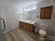 Bright bathroom featuring a double sink vanity, neutral tones, and wood-look flooring at 5238 Bethel Church Rd, Hickory, NC 28602