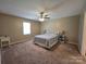 Cozy bedroom featuring a ceiling fan, large window, and neutral carpeting at 5238 Bethel Church Rd, Hickory, NC 28602