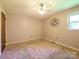 Bright bedroom featuring neutral carpet, ceiling fan, and a window offering natural light at 618 Springfield Nw Dr, Concord, NC 28027