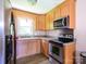 Well-lit kitchen featuring stainless steel appliances, wood cabinetry, and a window above the sink at 618 Springfield Nw Dr, Concord, NC 28027