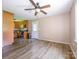 Spacious living room with modern ceiling fan, stainless steel appliances in adjacent kitchen, and wood-look flooring at 618 Springfield Nw Dr, Concord, NC 28027