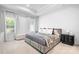 Calm bedroom with neutral tones, plush bed, decorative pillows, and natural light from the two windows at 6365 Ashton Park Dr, Denver, NC 28037