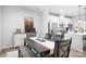Bright dining area with a rustic wood table, stylish seating, and an open view into the modern kitchen at 6365 Ashton Park Dr, Denver, NC 28037