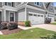 Close up view of the two-car garage with white doors and a grassy lawn at 6365 Ashton Park Dr, Denver, NC 28037