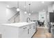 Bright, open kitchen with white cabinets, quartz countertops, stainless appliances, and a view into the dining room at 6365 Ashton Park Dr, Denver, NC 28037