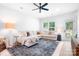 Sunlit living room with plush sectional sofa, neutral decor, ceiling fan and large windows for natural light at 6365 Ashton Park Dr, Denver, NC 28037