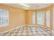 Spacious bonus room featuring checkered floors, natural light from many windows, and warm yellow walls at 6414 Goldenblush Cir, Charlotte, NC 28269
