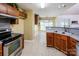 Functional kitchen with stainless steel appliances, wood cabinets, and a view into the breakfast nook at 6414 Goldenblush Cir, Charlotte, NC 28269