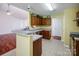 Well-lit kitchen featuring tile floors, laminate countertops, and wood cabinetry at 6414 Goldenblush Cir, Charlotte, NC 28269
