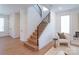 Inviting entryway featuring a staircase with black metal railings and light wood flooring throughout at 6711 Creft Cir, Lake Park, NC 28079