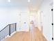 Bright hallway featuring wood floors, white walls, and black iron banister at 6711 Creft Cir, Lake Park, NC 28079