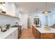 Well-lit kitchen with stainless steel appliances, large island with sink, and modern white and wood cabinetry at 6711 Creft Cir, Lake Park, NC 28079