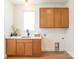 Bright laundry room featuring wood cabinets, white quartz countertop, and modern black faucet at 6711 Creft Cir, Lake Park, NC 28079