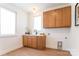 Bright laundry room with a sink, wooden cabinets, and natural light from two windows at 6711 Creft Cir, Lake Park, NC 28079