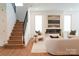 Inviting living room featuring a fireplace, staircase with black metal railings, and modern decor at 6711 Creft Cir, Lake Park, NC 28079
