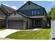 Rear exterior showcasing a garage and outdoor area with manicured lawn and space for entertaining at 6711 Creft Cir, Lake Park, NC 28079