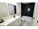Modern bathroom features double vanity, new fixtures, and sleek, dark tile at 703 Central Nw Dr, Concord, NC 28027